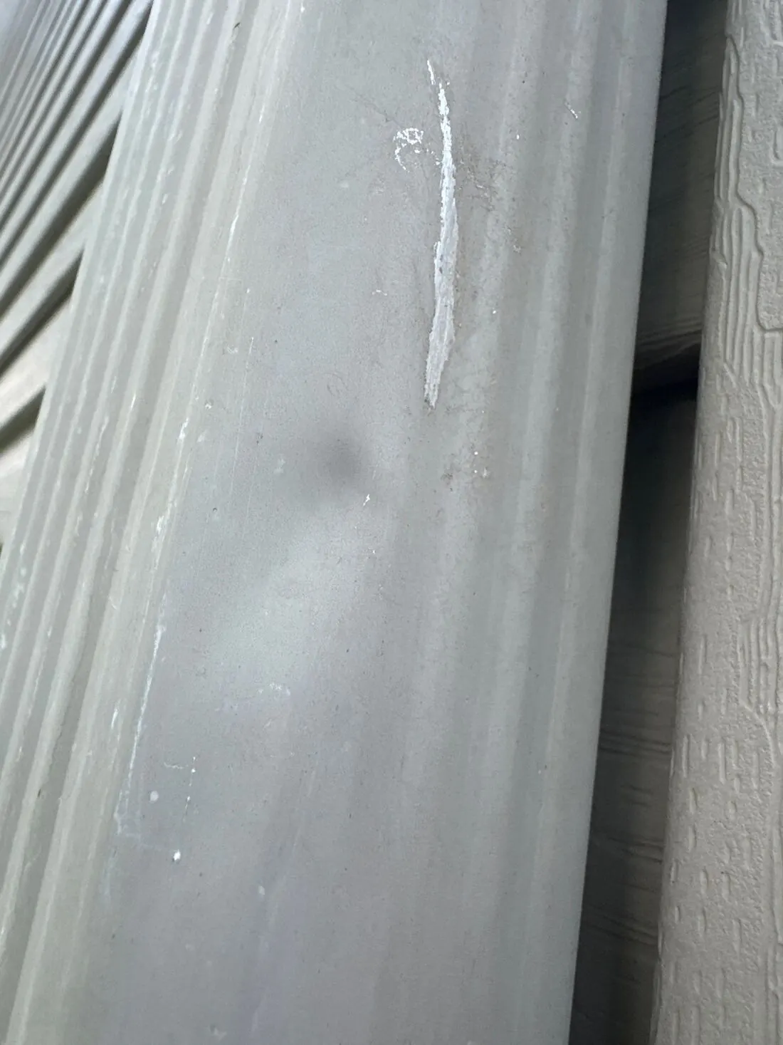 Downspouts: A dent and scuff from hail