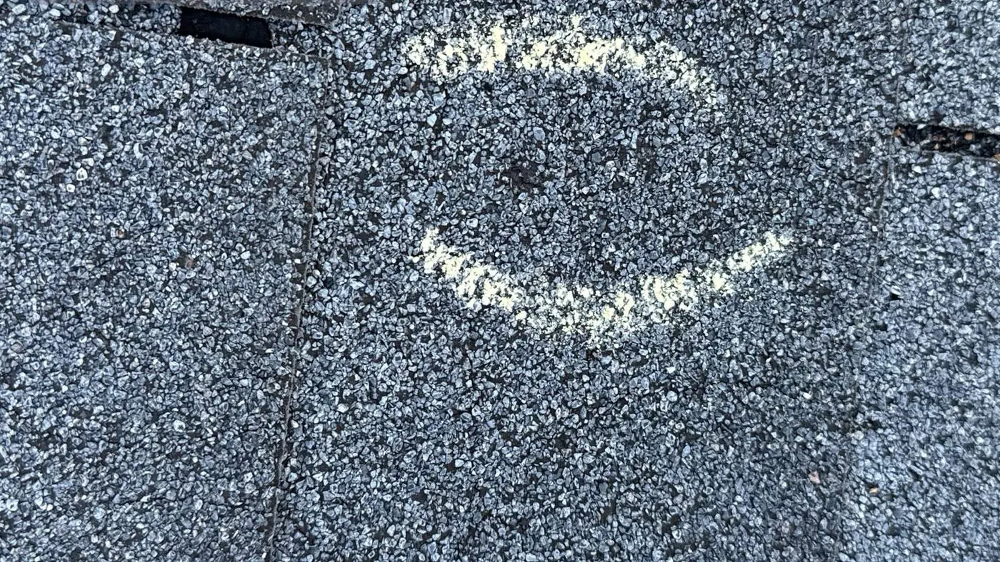 Hail hit circled in chalk on a shingle during a Lifetime Roofing inspection