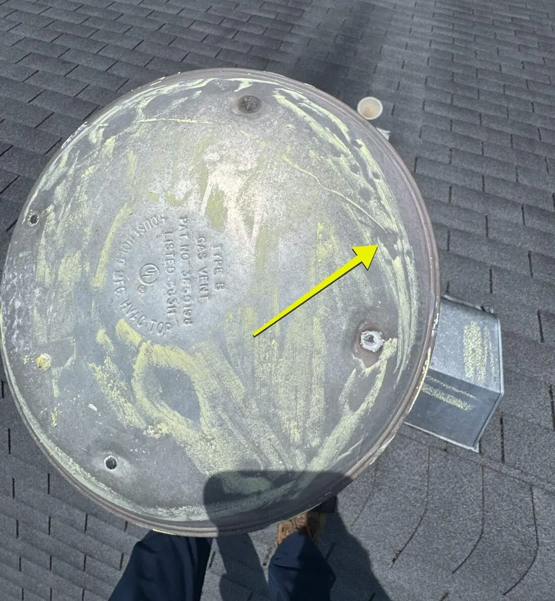 Roof vents: Chalk shows hail dents across a furnace vent cap
